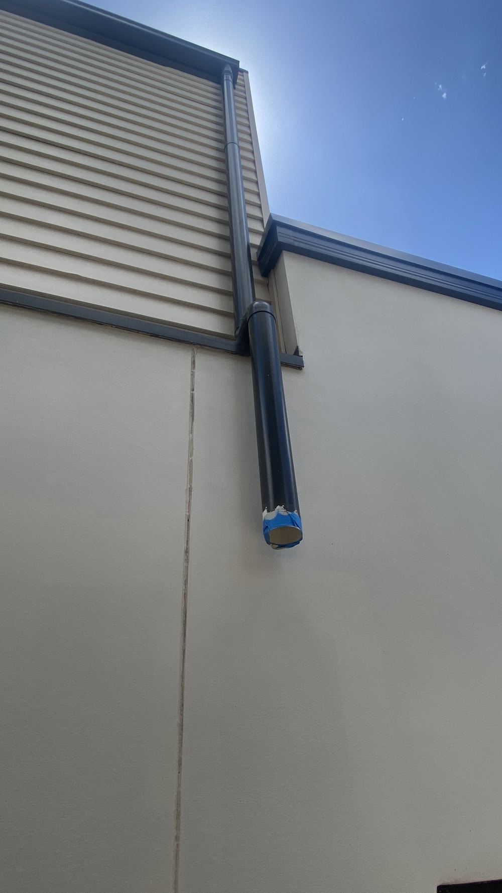 Downpipe disconnected from the stormwater line, dumping water at the slab edge, Tallawong