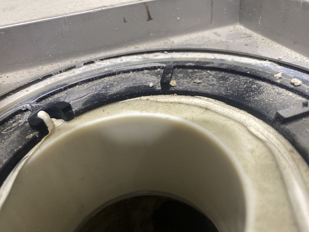 Open gap where the puddle flange meets the drain body, needing a flexible seal, found during a handover inspection in Tallawong